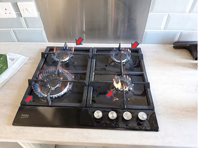 Illegally fitted gas hob showing yellow flames, signifying poor combustion