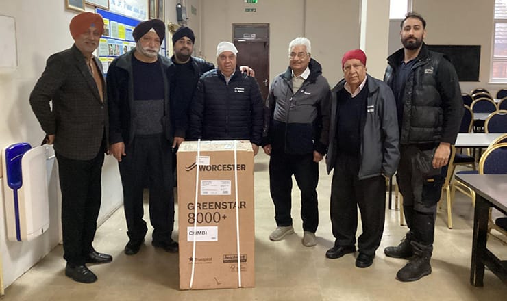 Trustees of Sri Guru Nakak Sikh Temple in Leeds with boiler installer Majinder Singh Thethi, owner of Thethi Builders. A Worcester Bosch boiler in a box is in front of them