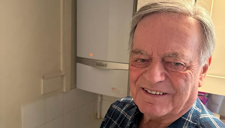 Veteran radio DJ Tony Blackburn standing in front of a gas boiler