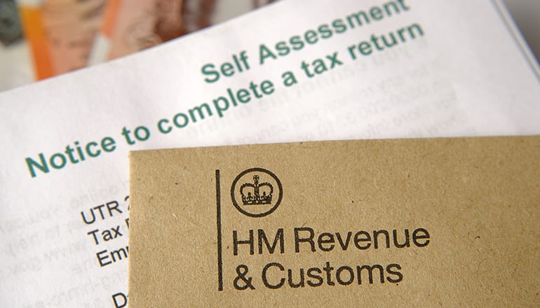 Envelope showing HMRC logo on top of a form to complete a self-assessment tax return
