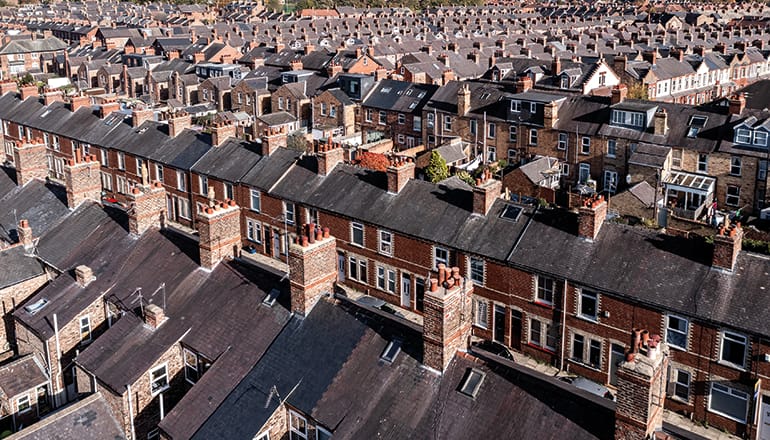 Aeriel view of tightly packed urban UK streets, showing roofs and chimneys